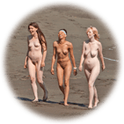three nude women go for a stroll down the beach